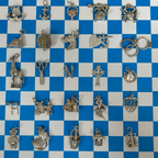 Collection of various silver charms on a blue and white checkered background