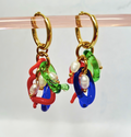 Colorful hoop earrings with gold hooks on a clear stand against a white background