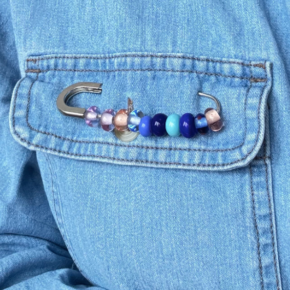 Colorful beaded hook attached to a blue denim jacket
