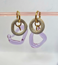 Pair of earrings with gold loops and pinkish-purple rings on a light gray background